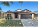 House exterior with a two-car garage and well-maintained lawn at 7927 Oakstone Ct, Orlando, FL 32822