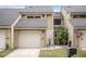 Tan two-story townhouse with attached garage and landscaped front yard at 8133 Citrus Chase Dr, Orlando, FL 32836