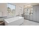 Modern bathroom with gray cabinets and a large bathtub at 10631 Royal Cypress Way, Orlando, FL 32836