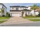 Two-story house with solar panels, a three-car garage, and a manicured lawn at 10631 Royal Cypress Way, Orlando, FL 32836