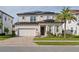 Two-story house with solar panels, a three-car garage, and a manicured lawn at 10631 Royal Cypress Way, Orlando, FL 32836