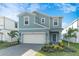 Two-story home with gray siding, white garage door, and landscaped front yard at 1200 Aloha Blvd, Davenport, FL 33897