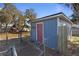 Blue shed with red door in backyard, surrounded by chain link fence at 1325 Paperwoods Dr, St Cloud, FL 34772