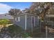 Gray shed with red door and window in fenced backyard at 1325 Paperwoods Dr, St Cloud, FL 34772