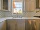 Modern kitchen with gray cabinets, marble countertops, and a stainless steel sink at 13305 Lacebark Pine Rd, Orlando, FL 32832