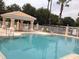 Community pool with gazebo and lounge chairs at 13536 Turtle Marsh Loop # 538, Orlando, FL 32837