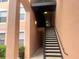 A stairwell with stairs leading up to apartments, featuring stucco walls and adequate lighting for safety and visibility at 13536 Turtle Marsh Loop # 538, Orlando, FL 32837