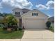 Two-story house with a two-car garage and landscaped front yard at 14515 Huntcliff Park Way, Orlando, FL 32824