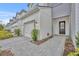 Front entry and walkway of townhome with gray and white siding and paver driveway at 1479 Brookdale Ct, Oviedo, FL 32765