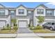 Two-story townhome with gray and white siding, two-car garage, and landscaped front yard at 1479 Brookdale Ct, Oviedo, FL 32765