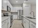 Modern kitchen with white cabinets, stainless steel appliances, and quartz countertops at 1479 Brookdale Ct, Oviedo, FL 32765