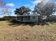 Back view of light green home with enclosed patio and ample backyard with shade trees at 14912 Sw 35Th Cir, Ocala, FL 34473
