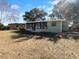 Back view of light green home with enclosed patio and ample backyard with shade trees at 14912 Sw 35Th Cir, Ocala, FL 34473