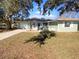 Newly renovated light green house with a blue door, solar panels, and a well-maintained lawn at 14912 Sw 35Th Cir, Ocala, FL 34473