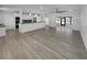 Spacious living room with modern gray flooring, stylish lighting fixtures, and an open layout flowing into the kitchen at 14912 Sw 35Th Cir, Ocala, FL 34473