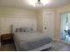 Cozy bedroom with a queen bed, nightstand, and access to the patio at 2592 Grassy Point Dr # 106, Lake Mary, FL 32746