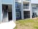 Exterior of a multi-story blue building with stairs and lawn at 2592 Grassy Point Dr # 106, Lake Mary, FL 32746