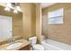 Bathroom with tub, toilet, granite countertop, and wood cabinets at 2607 E Jefferson St, Orlando, FL 32803