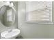 Small bathroom with pedestal sink, oval mirror and window blinds at 2607 E Jefferson St, Orlando, FL 32803