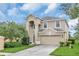 Tan two-story house with a two-car garage and lush landscaping at 2715 Manesty Ln, Kissimmee, FL 34747