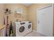 Bright laundry room with washer, dryer, and storage shelves at 2715 Manesty Ln, Kissimmee, FL 34747