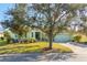 Light green house with a paved driveway and large oak tree at 300 Sorrento Rd, Poinciana, FL 34759