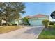 Light green house with a paved driveway and manicured lawn at 300 Sorrento Rd, Poinciana, FL 34759