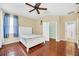 Bright bedroom with wood-look tile floors, ceiling fan, and white double bed at 306 Kettering Rd, Davenport, FL 33897