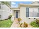 Front entrance of the house featuring a dark gray door and gray siding with shutters at 306 Kettering Rd, Davenport, FL 33897