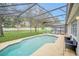 Relaxing screened pool area with patio furniture and lush landscaping at 306 Kettering Rd, Davenport, FL 33897