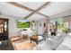 Living room with exposed beams, white couch, and brick feature wall at 322 Apopka St, Winter Garden, FL 34787