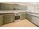 Kitchen with dark green cabinets and stainless steel appliances at 4957 Rock Rose Loop, Sanford, FL 32771