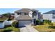 Two-story house with a gray exterior, two-car garage, and landscaped yard at 5417 Calla Lily Ct, Kissimmee, FL 34758