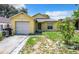 Cute yellow house with a single car garage and small front yard at 5633 Piney Ridge Dr, Orlando, FL 32808