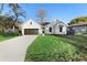 Charming farmhouse-style home with a dark brown garage door and manicured lawn at 58 Bonita Rd, Debary, FL 32713