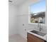 Laundry room with utility sink, shelving, and a window overlooking the backyard at 58 Bonita Rd, Debary, FL 32713