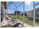 Relaxing screened porch with patio furniture and backyard view at 5942 Nw 26Th Ln, Ocala, FL 34482