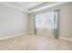 Spacious bedroom with light gray walls and large windows with curtains at 597 Lost Shaker Way, Daytona Beach, FL 32124