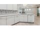 Modern kitchen with white cabinets, quartz countertops, and a dishwasher at 597 Lost Shaker Way, Daytona Beach, FL 32124