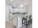 Modern white kitchen with breakfast bar, pendant lighting, and stainless steel appliances at 597 Lost Shaker Way, Daytona Beach, FL 32124