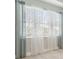 White sheer curtains and blue linen curtains hang on a window at 597 Lost Shaker Way, Daytona Beach, FL 32124