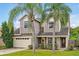 Two-story house with gray siding, beige garage door, and palm trees at 605 Brightview Dr, Lake Mary, FL 32746