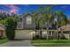 Two-story house with gray siding, beige garage door, and palm trees at 605 Brightview Dr, Lake Mary, FL 32746