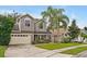 Two-story house with gray siding, beige garage door, and palm trees at 605 Brightview Dr, Lake Mary, FL 32746