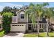 Two-story house with gray siding, beige garage door, and palm trees at 605 Brightview Dr, Lake Mary, FL 32746