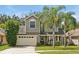 Two-story house with beige garage door and palm trees at 605 Brightview Dr, Lake Mary, FL 32746