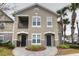 Two-story condo building with two units, featuring balconies and landscaping at 6554 Swissco Dr # 53, Orlando, FL 32822