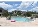 Community pool with surrounding patio furniture and landscaping at 6554 Swissco Dr # 53, Orlando, FL 32822