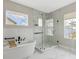 Modern bathroom with marble shower, soaking tub, and herringbone tile at 6921 Arnoldson St, Orlando, FL 32827