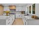 Modern kitchen with white cabinets, quartz countertops, and a wood accent wall at 7 1 St Ct, Windermere, FL 34786